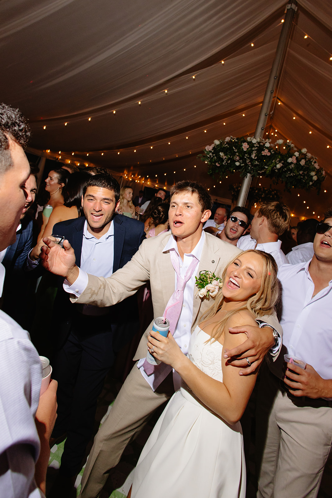Bride and groom singing along on a packed dance floor